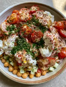 High-angle view of golden chickpeas, precision-diced cucumbers, and jewel-toned tomatoes in a ceramic bowl. (Non-Lettuce Salad Recipes)