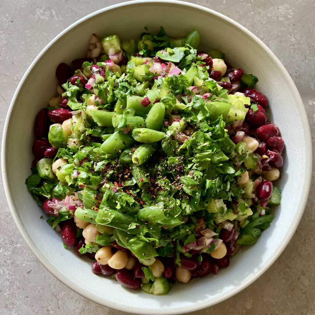 Close up of Three-bean diabetic-friendly salad glinting with lemon-herb vinaigrette and red pepper flakes.