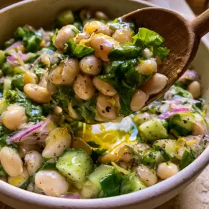 Extreme close-up of Lemon Basil Bean Salad showing glossy cannellini beans and fresh torn basil leaves.