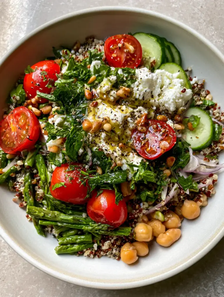 Asparagus Chickpea Quinoa Salad with Lemon Herb Vinaigrette 1 Close-up of fluffy tri-color quinoa mixed with blanched asparagus tips, toasted pine nuts, and lemon-herb vinaigrette.