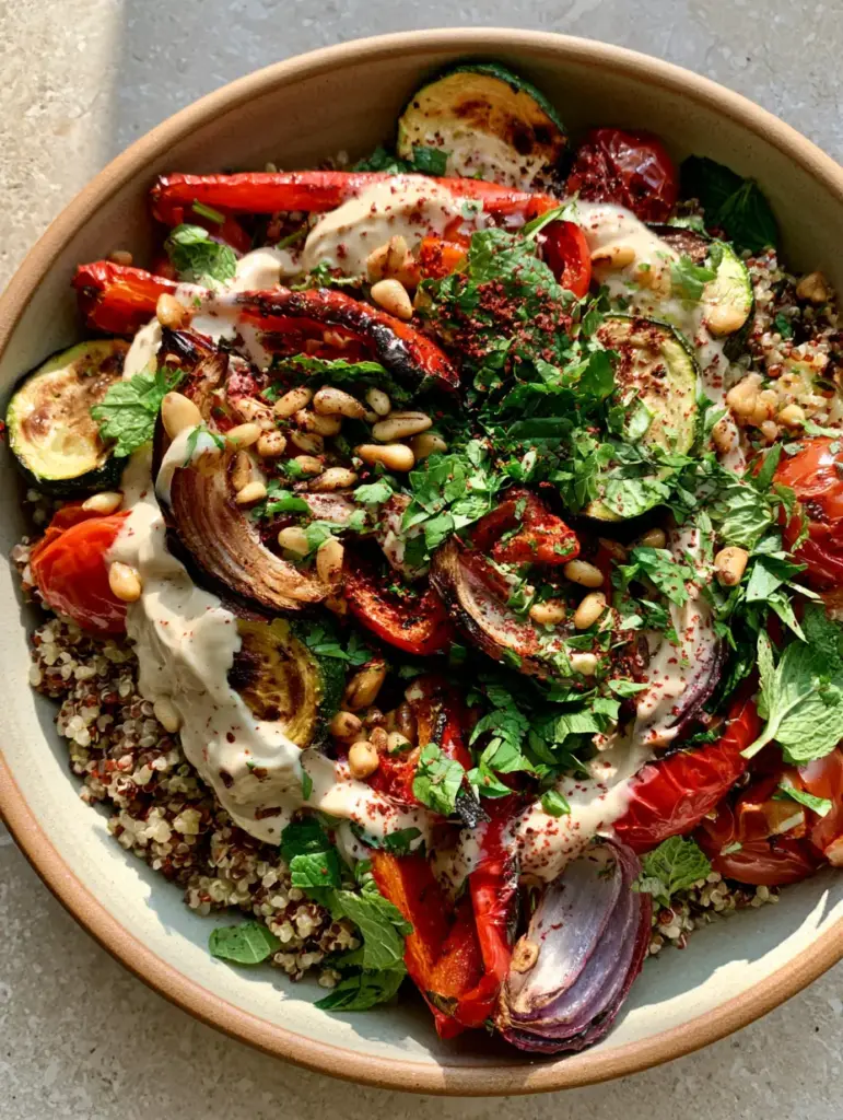 Roasted vegetable quinoa salad with Creamy Lemon Tahini Dressing 2 Macro top-down view of Roasted vegetable quinoa salad in a ceramic bowl showing charred zucchini and red peppers.