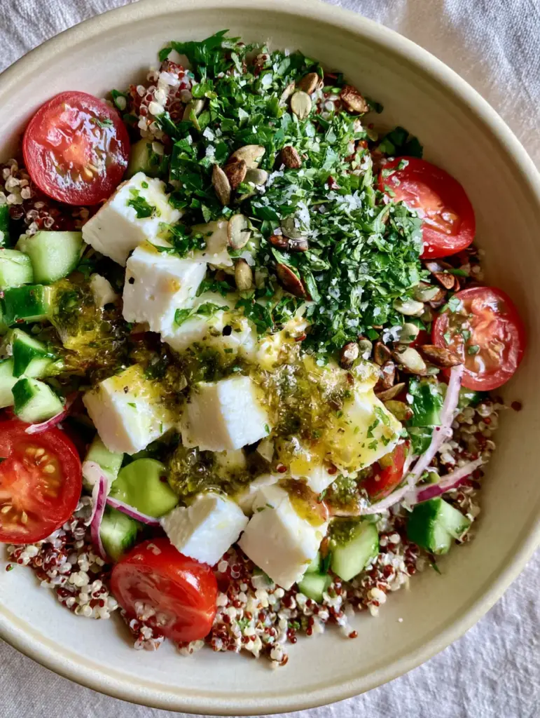 Close up of tri-color Quinoa Salat with creamy feta, red onions, and toasted pumpkin seeds.