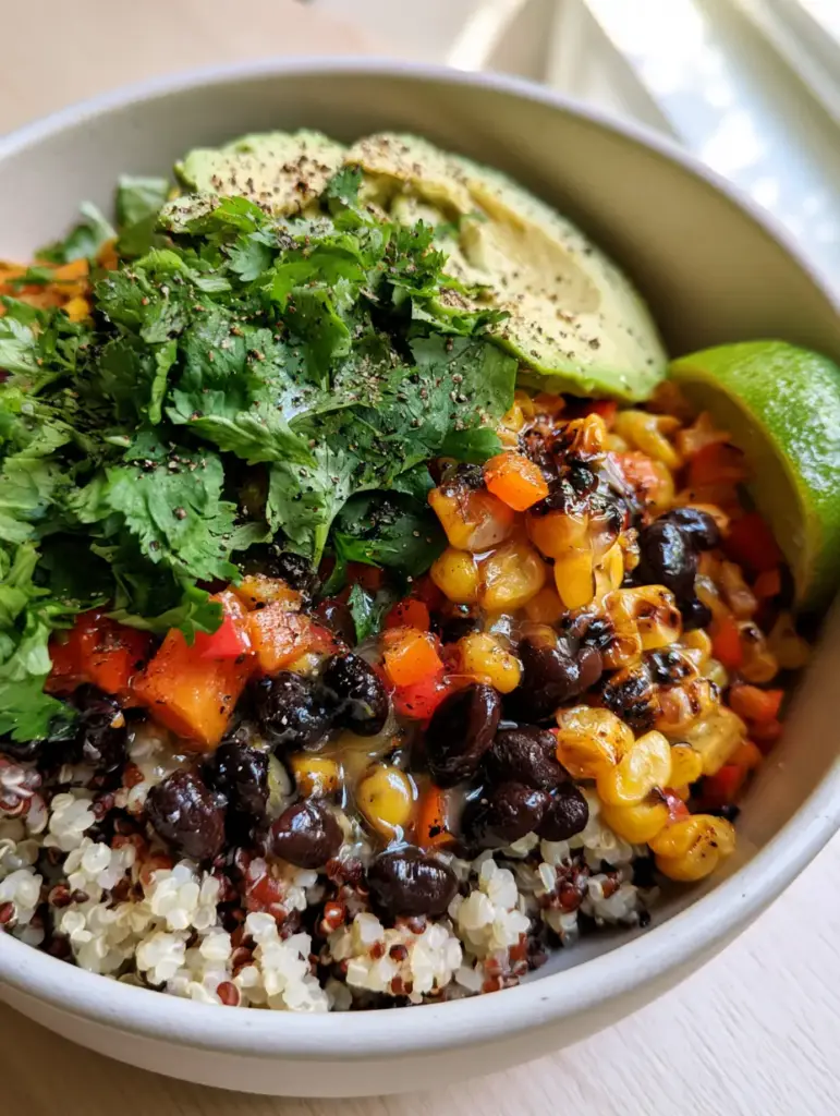 Black Bean and Corn Quinoa Salad with Charred Corn and Avocado 1 Top-down view of a healthy Black Bean and Corn Quinoa Salad with glistening lime vinaigrette and fresh cilantro.